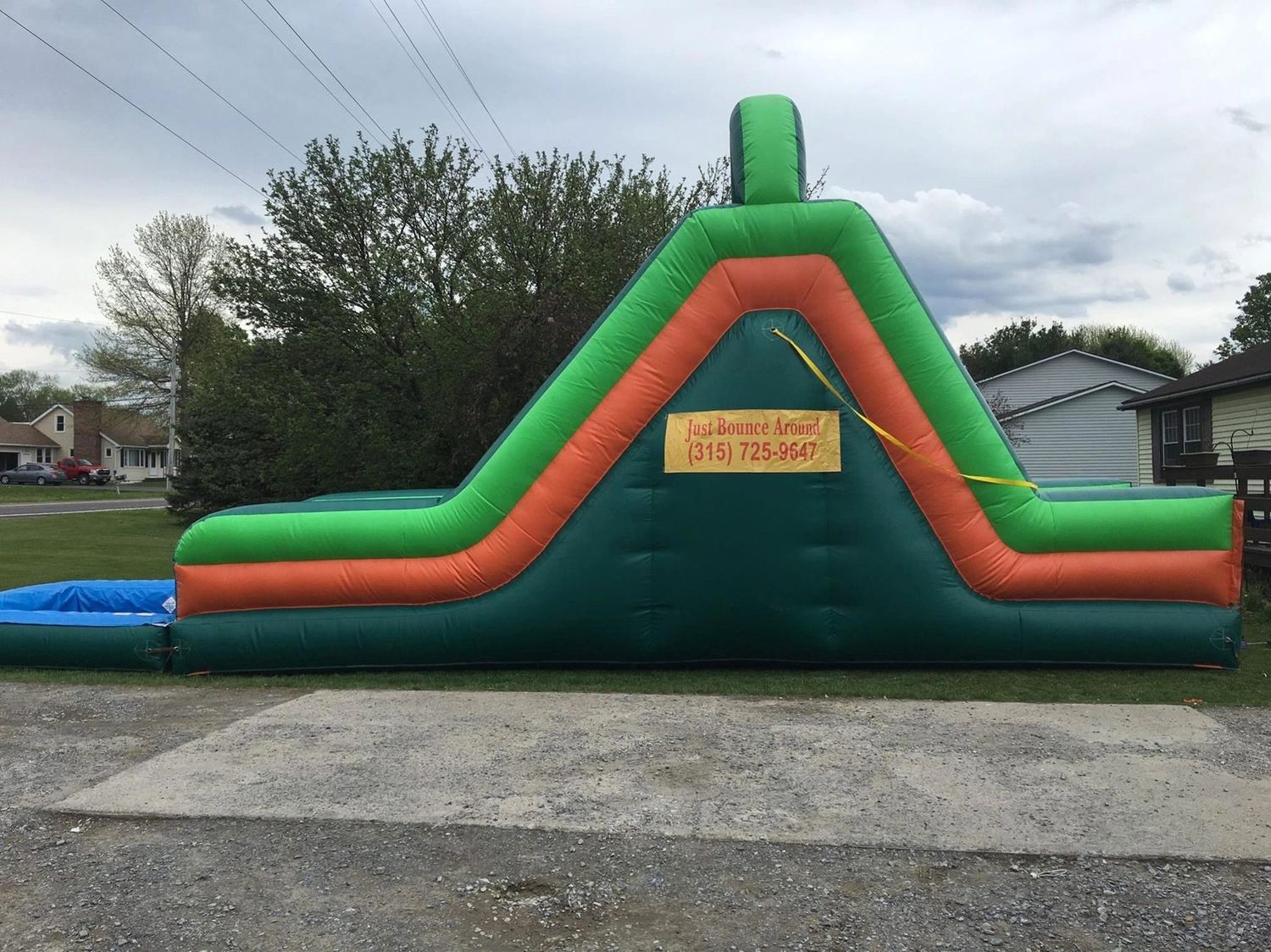 A Just Bounce Around inflatable slide set up on a sunny lawn